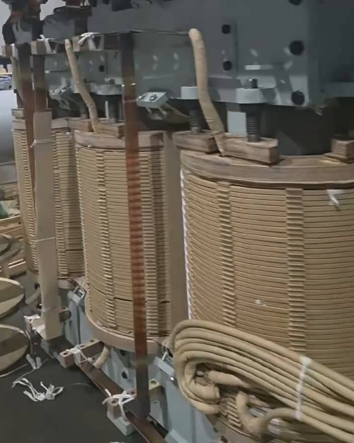 Three wound coils assembled on a transformer core, with insulated leads