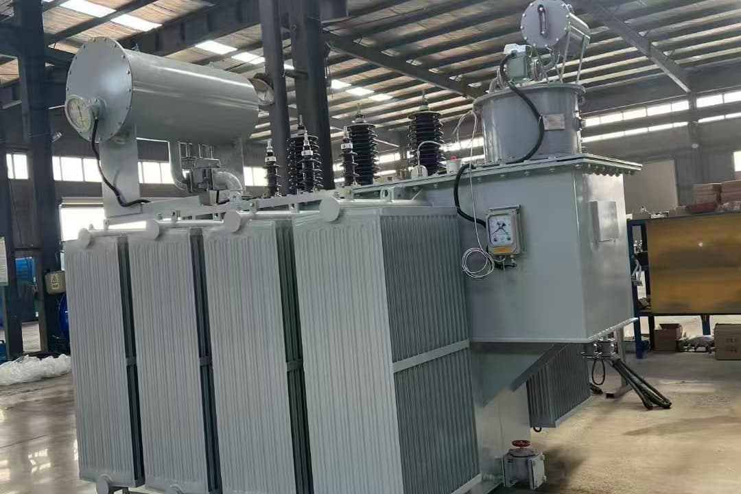 Oil-immersed transformer with radiator banks, a conservator and an on-load tap-changer compartment, in the factory hall