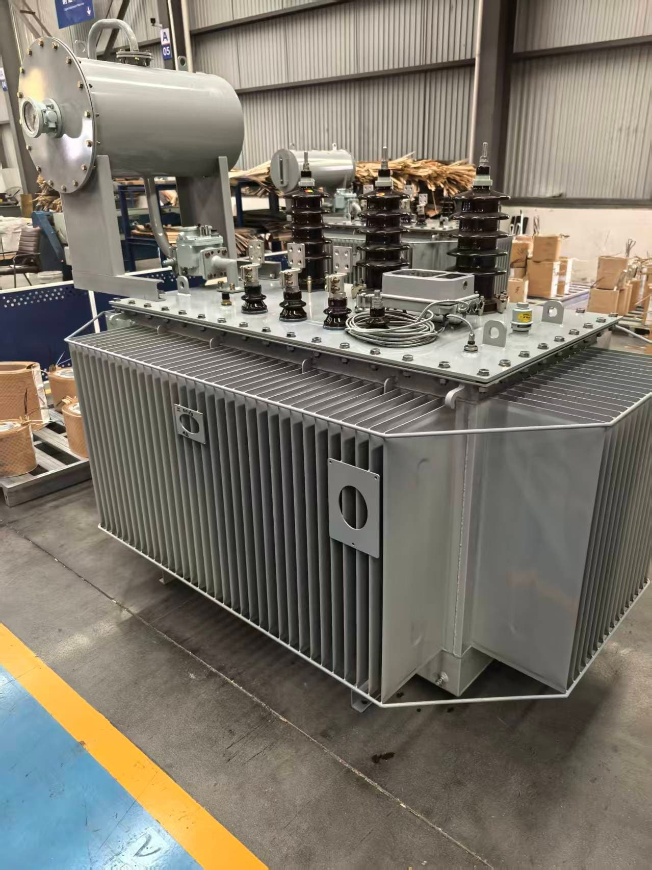 Close view of an oil-immersed transformer with a corrugated tank and a conservator